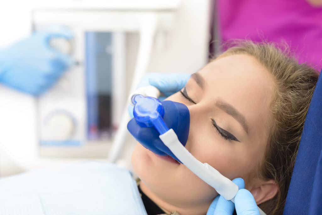 Blonde woman looks relaxed in her dental chair while undergoing sedation dentistry.