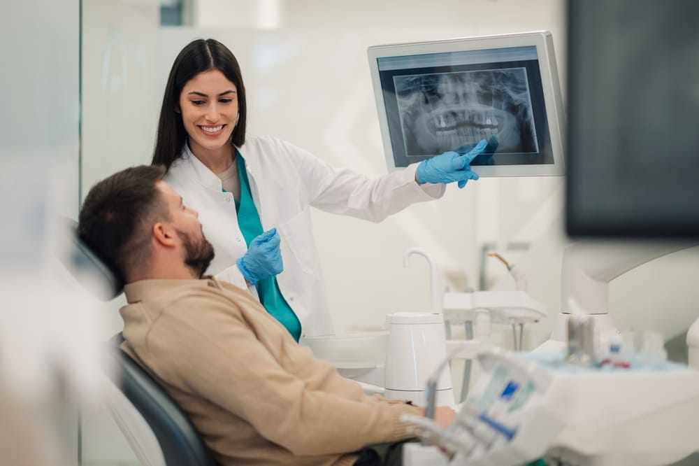 Dental professional shows digital x-ray images to patient.