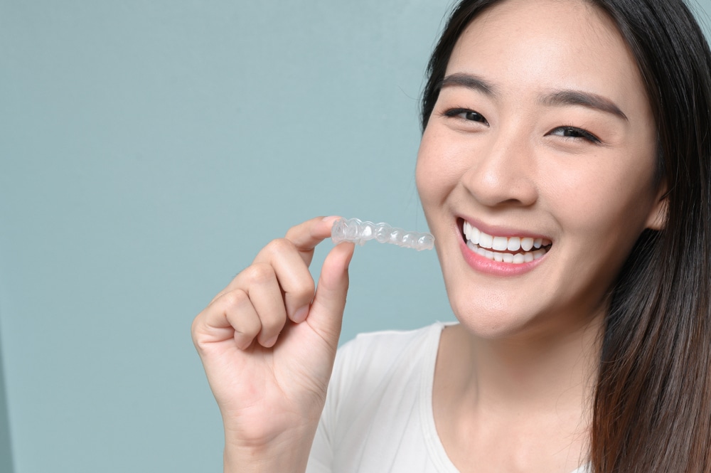 Woman who completed clear aligner treatment maintains her results with a retainer.