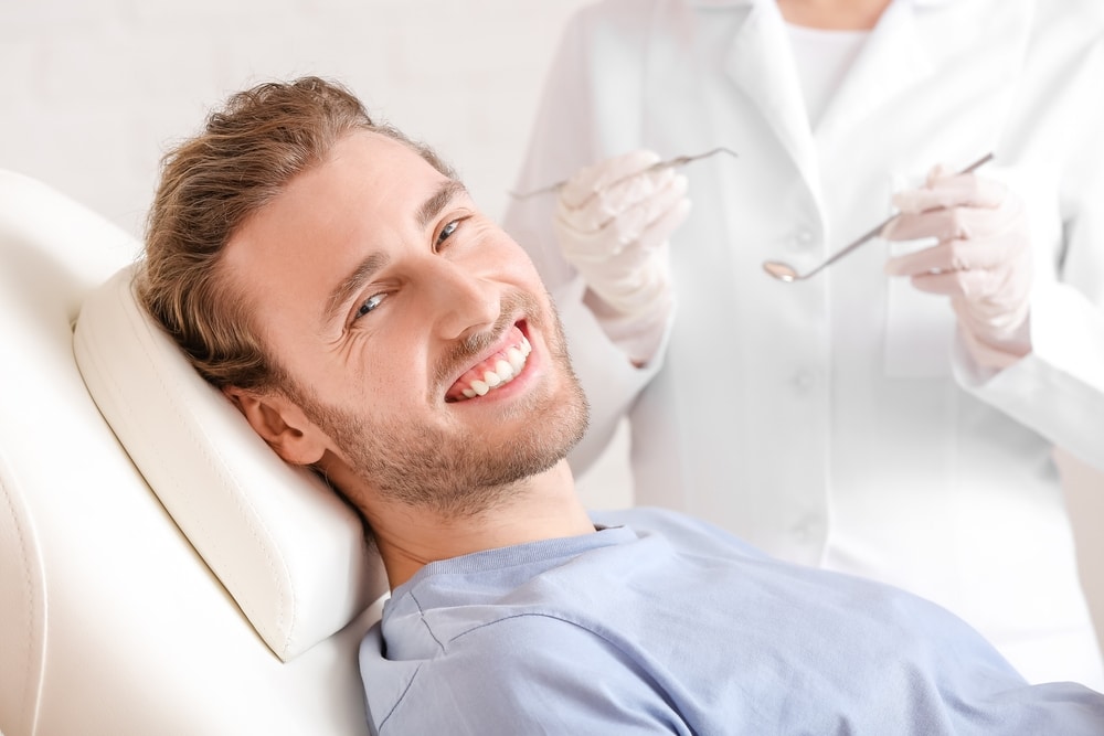 Man in his early 30s sits down for a routine dental exam.